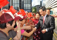 The Chief Executive Mr C Y Leung and his wife Regina greet members of the public before the flag-raising ceremony at Golden Bauhinia Square on July 1.